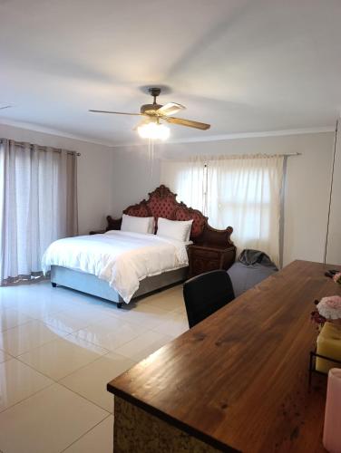 a bedroom with a bed and a table in it at Siyapeya Household in Bellville