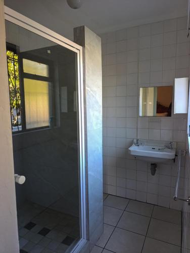a bathroom with a shower and a sink at Siyapeya Household in Bellville