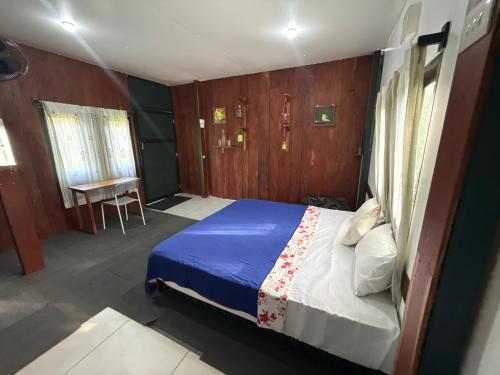 a bedroom with a bed and a table in it at Whispering Willows in Gūdalūr