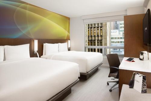ein Hotelzimmer mit 2 Betten und einem Schreibtisch in der Unterkunft LUMA Hotel - Times Square in New York