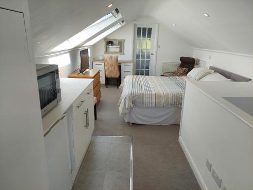 a bedroom with a bed and a television in a room at Avalon Guest Suite Ewell in Ewell