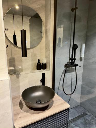 a bathroom with a sink with a mirror and a shower at Apartman KATY - self check-in, besplatan parking, blizu centra in Vukovar