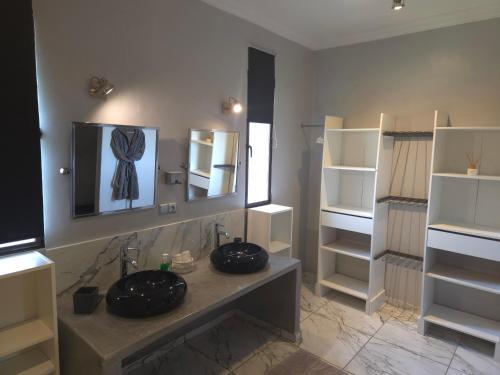 a bathroom with two sinks and a mirror and shelves at Villa Serenity MARRAKECH in Oulad Mazoug