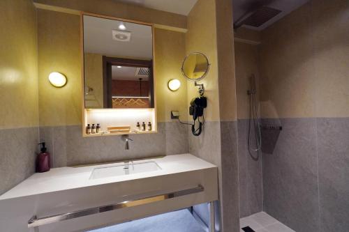 a bathroom with a sink and a mirror and a shower at Ionian Crown Suites in Barbati in Barbati