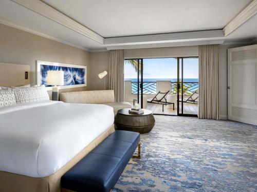 a bedroom with a bed and a view of the ocean at Fairmont Orchid in Waikoloa