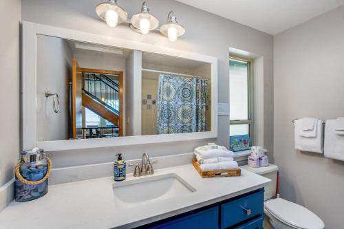a bathroom with a sink and a mirror and a toilet at Olympus View Home in Port Ludlow