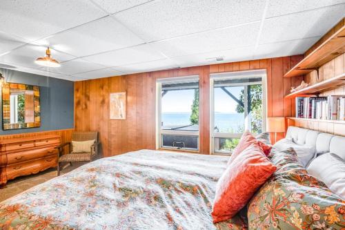 a bedroom with a large bed and windows at Olympus View Home in Port Ludlow