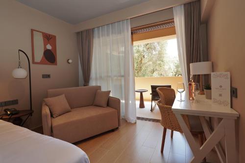 a bedroom with a bed and a desk and a chair at Ionian Crown Suites in Barbati in Barbati