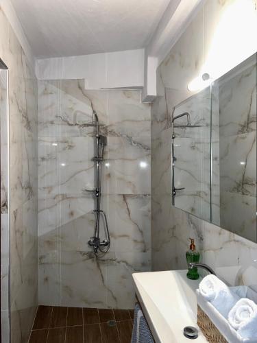 a bathroom with a shower and a sink at Sea and Stone Apartment in Afitos