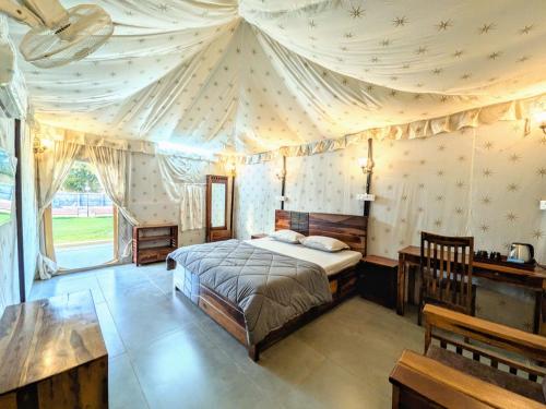 a bedroom with a bed with a tent ceiling at Whispering Woods in Gorthan