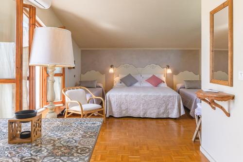 a bedroom with a bed and a chair and a lamp at Casa Aloe B&B in Monte San Savino