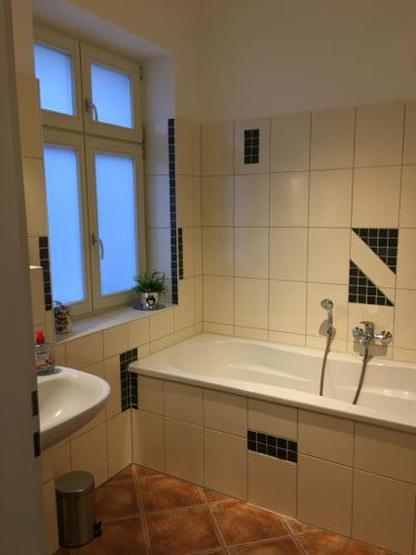 a bathroom with a tub and a sink at Familienhaus Stadtmitte in Neustrelitz