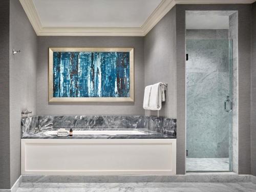 a bathroom with a tub and a glass shower at Fairmont Olympic Hotel in Seattle
