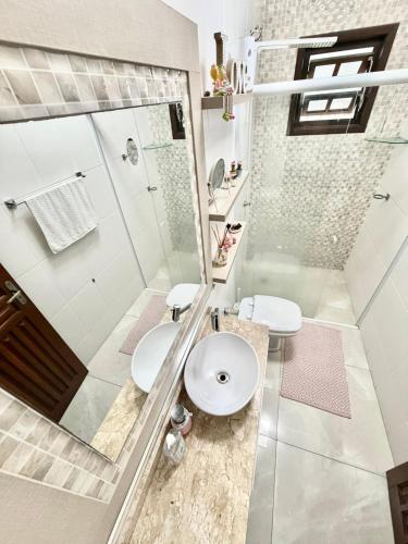 a bathroom with a shower and a toilet and a sink at Quarto 2P Joinville Costa e Silva perto Centro in Joinville