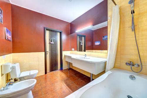 a bathroom with two sinks and a tub and a toilet at Terra Nova Spa Hotel in Hatne