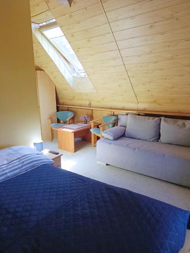 a bedroom with a bed and a couch in a room at Dom Pod Gruszką in Pobierowo