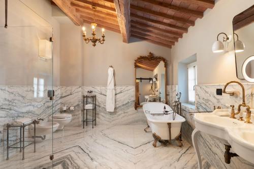 a bathroom with two sinks and a tub and two toilets at Villa Petriolo - Small Luxury Hotels of the World in Cerreto Guidi