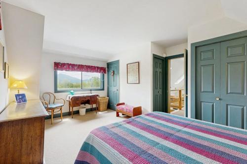 a bedroom with a bed and a desk and a table at GOPI Notch in Franconia