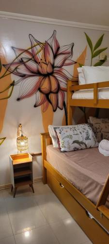 a bedroom with a flower mural on the wall at Casa ao mar -Pousada Itapema in Itapema