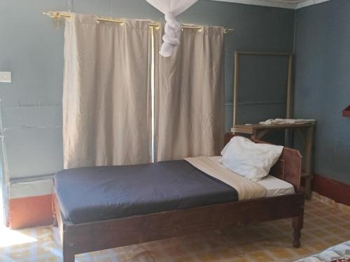 a bed sitting in a room with a window at Turacova Safaris & Accommodation in Mara Simba