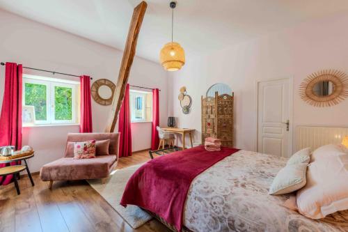 a bedroom with a large bed and a chair at Les Tilleuls de Marie in Saint-Edmond