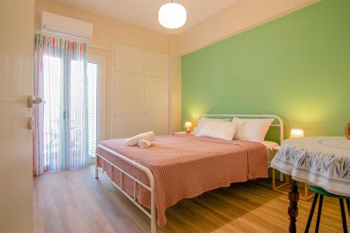 a green bedroom with a bed and a window at MC4 Residences in Loutraki