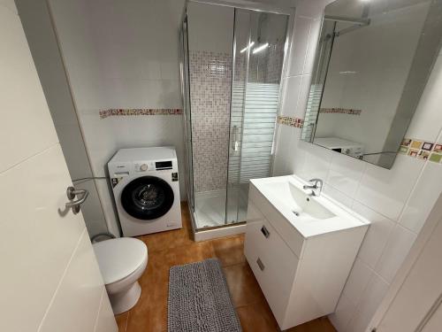 a bathroom with a toilet sink and a washing machine at Las Arenas Playa del Ingles Apartment 413 in San Bartolomé