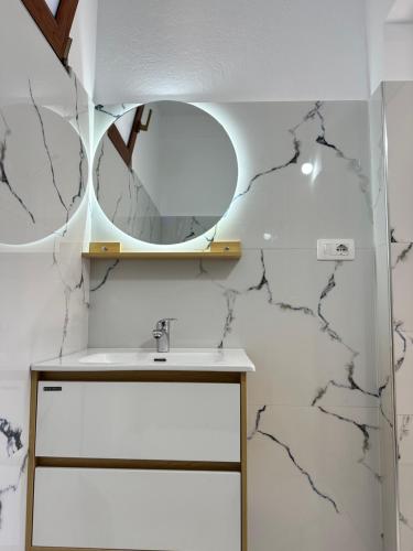 a bathroom with a sink and a mirror at Magnus Appartments in Dukat