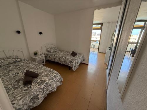 a bedroom with two beds and a balcony at Las Arenas Playa del Ingles Apartment 413 in San Bartolomé