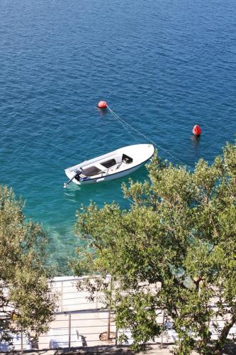 a white boat in the water next to a dock at Villa Ancora in Neum