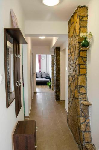 a hallway of a house with a stone wall at Privet Apartman in Balatonfüred