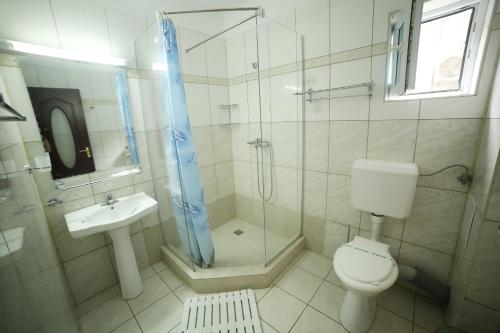 a bathroom with a shower and a toilet and a sink at Hotel Diandra in Eforie Nord