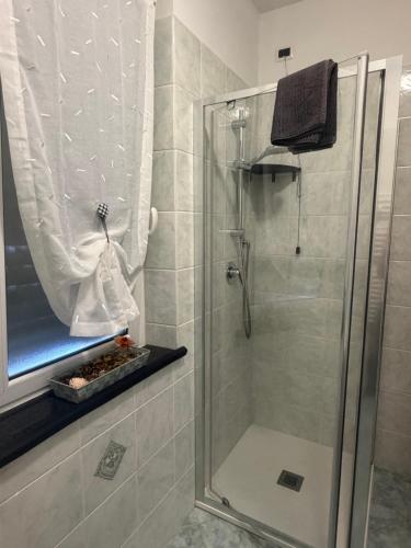 a bathroom with a shower with a glass door at NORA House in Savona