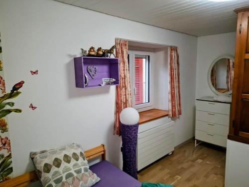 a room with a purple couch and a window at Maison mitoyenne avec terrasse in Asuel