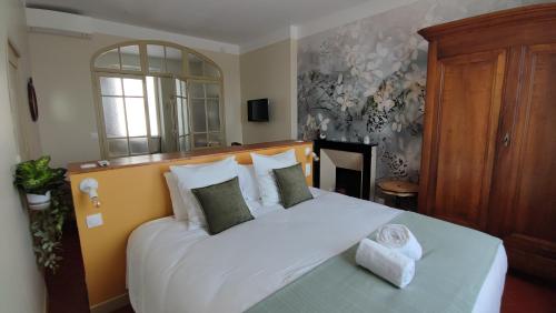 a bedroom with a large white bed with pillows at Les Terrasses d'Antonin in Grambois