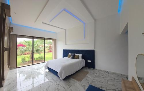 a bedroom with a bed and a large window at Villa Serenity MARRAKECH in Oulad Mazoug