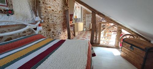 a bedroom with a bed in a room with a staircase at Gîte L'air De Vacances in Bonnée