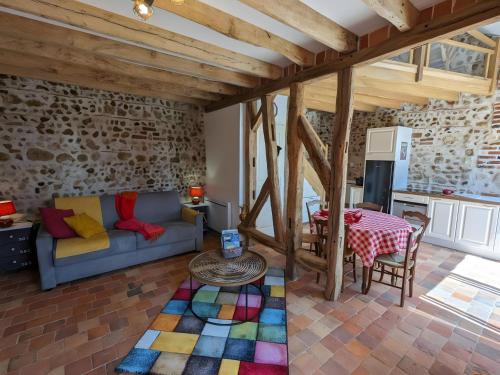 a living room with a couch and a table at Gîte L'air De Vacances in Bonnée
