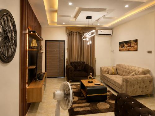 a living room with a couch and a tv at Restnest suite in Benin City