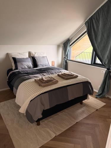 a bedroom with a large bed and a window at ScenicOceanview 4Free parking space 18 mins Downtown in Álftanes