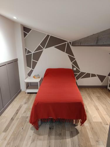 a bedroom with a bed with a red blanket at Hébergement quartier historique in Parthenay