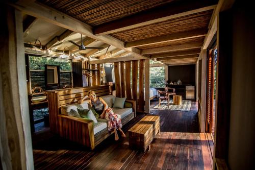 a woman sitting on a couch in a living room at Morgan's Rock in San Juan del Sur
