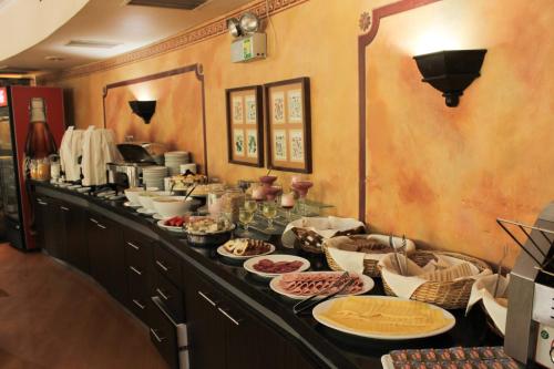 a kitchen with a buffet of food on a counter at Hotel Leonardo da Vinci in Santiago