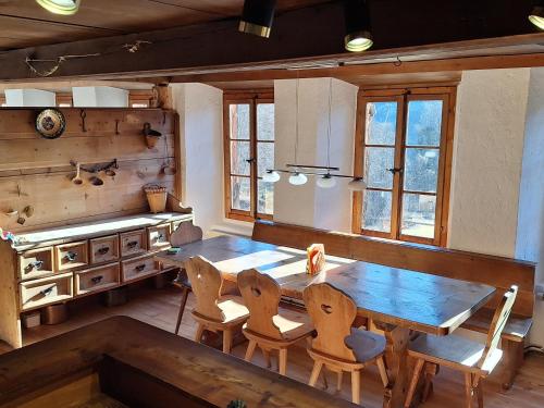 a dining room with a wooden table and chairs at Rauft-Perfekter Rückzugsort für besondere Feierlichkeiten 2500 m2 Grundstück mitten in der Natur in Hasliberg