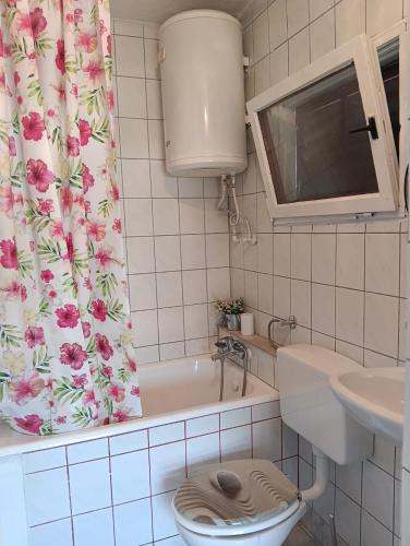 a bathroom with a toilet and a shower curtain at Studio apartman Matea in Budačka Rijeka