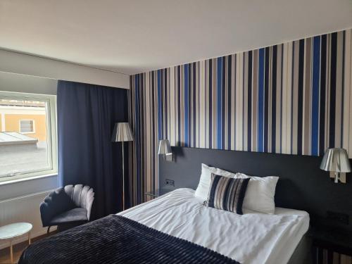 a hotel room with a bed and a chair at Quality Hotel Statt in Hudiksvall