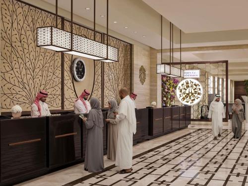 a group of people standing in a hotel lobby at Swissotel Makkah in Mecca