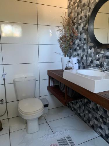 a bathroom with a toilet and a sink at Casa mussambé in Sao Jorge