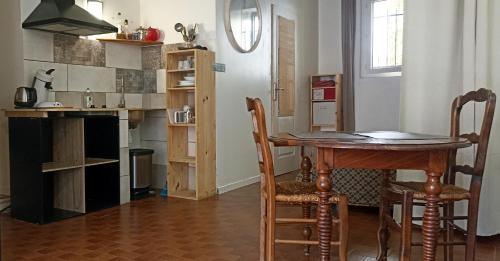 a kitchen with a table and chairs in a room at Studio privé - maison de village in Valensole