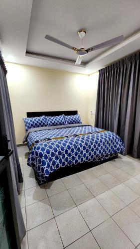 a bedroom with a bed with a blue comforter at Executive Deluxe Studio Apt-Osu in Christiansborg